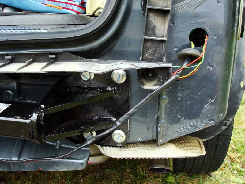 ...faire passer le faisceau de l'attelage par le passage situé sur la droite de l'aile en préperçant le bouchon de caoutchouc pour préserver l'étanchéité.